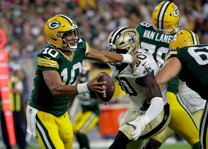 Packers quarterback Jordan Love (10) scrambles in the pocket as Saints defensive end Tanoh Kpassagnon (90) closes in. Tork Mason / USA TODAY NETWORK